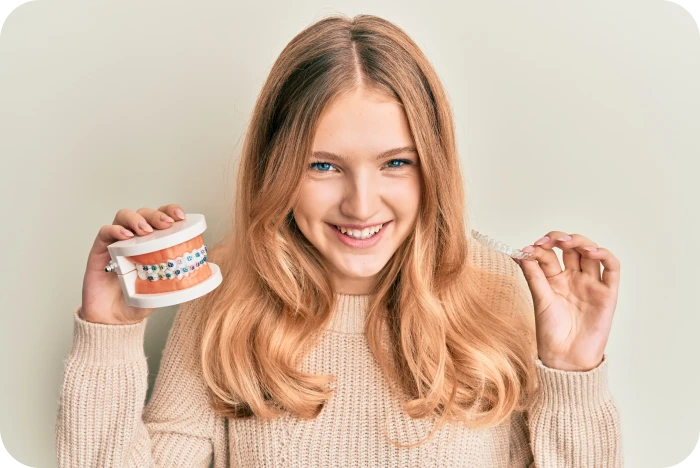 Adolescente présentant un appareil multi-attaches et un aligneur orthodontique transparent