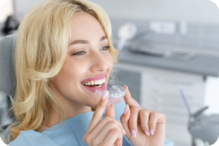 atiente adulte présentant un aligneur transparent lors d’un rendez-vous d’orthodontie