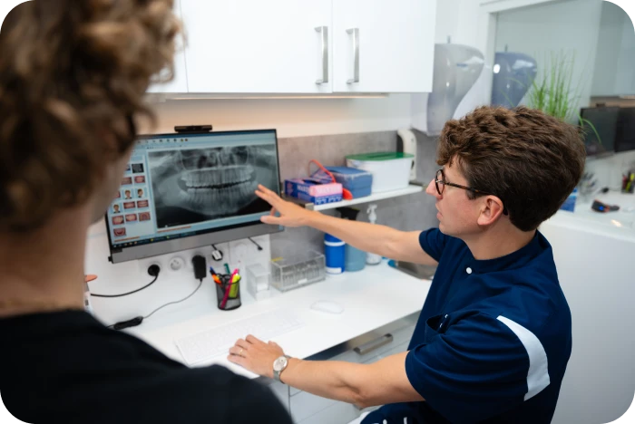 Praticien présentant une radiographie panoramique lors d’un bilan orthodontique