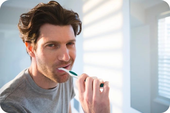 Patient adulte se brossant les dents pendant son traitement orthodontique