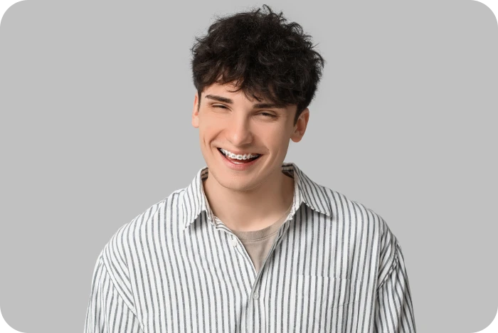 Adolescent souriant avec un appareil orthodontique multi-attaches