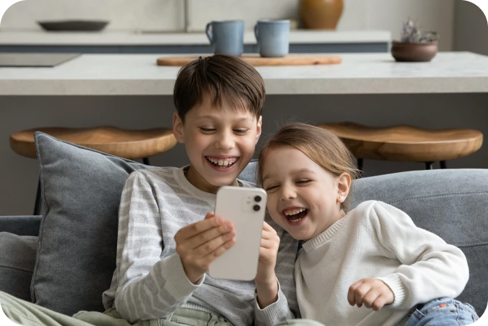 Enfants souriants assis sur le canapé