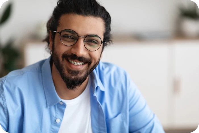 Patient adulte souriant portant un appareil dentaire multi-attaches