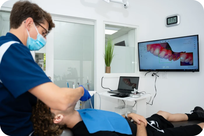 Praticien réalisant un scan intra-oral 3D pendant une consultation orthodontique